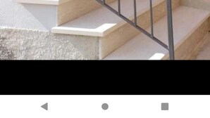 A staircase with metal railings leading to a wooden door. - In Posticastello ideal for a relaxing stay with family or company (Castelluccio Superiore)