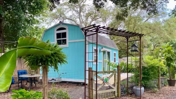 A blue house with a wooden pergola in a garden. - Perdido Surf Shack-tiny home on a hobby farm close to Perdido Key Beach and NAS (Pensacola)
