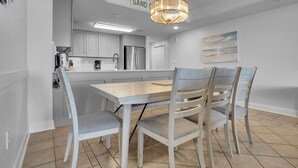 A modern kitchen with a central island, white cabinetry, and a pendant light. - Anderson Ocean Club #1611 (Myrtle Beach)