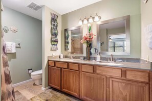 Une salle de bain avec un meuble-lavabo en bois, un grand miroir et une douche.