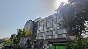 Un edificio residencial de varios pisos con diseño moderno, que presenta grandes ventanales y una combinación de materiales en la fachada.