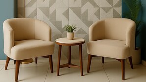 A room with two beige armchairs, a small round table with a potted plant, and a floor lamp. - HOTEL HARDIK PALACE - NOIDA (Noida)