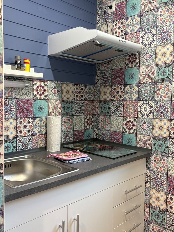 A kitchen with a modern design, featuring a patterned backsplash, a built-in oven, and a stainless steel sink. - Air-conditioned vacation home on the Rennsteig with a terrace and large garden (Gerstungen)