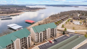A lakeside hotel with multiple buildings, a dock, and a parking area. - Waters Edge Retreat - For 6! (Branson)