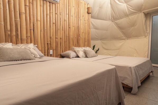 A room with two beds, a bamboo wall, and a tent-like structure. - Bambuk Bio Dome Uvita Beach Front (Uvita)