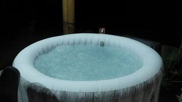 A hot tub with a control panel on top, surrounded by a wooden structure.