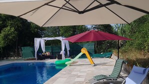 Une piscine équipée de chaises longues et de parasols.