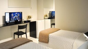 A hotel room with two beds, a desk with a computer, a chair, and a TV. - HOTEL SUITES RESIDENCE (Recife)