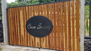 A wooden gate with a circular sign that reads "Casa Suitez".