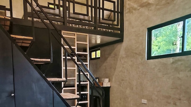 A modern interior with a staircase, a built-in bench, and a window with a view.