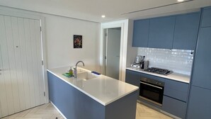 Une cuisine moderne dotée d’un îlot central, d’un four encastré et d’une cuisinière.