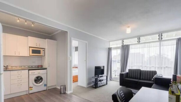 Een modern appartement met keuken, eethoek en woonkamer.