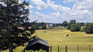 A rural landscape with a fenced field, a small building, and a large tree. - Charming Farmhouse Getaway With Stunning Mountain Views, Near Gettysburg  (Taneytown)