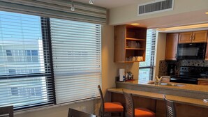 A modern kitchen with a microwave, stove, and built-in oven. There is a dining area with a round table and chairs.