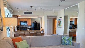 A modern living room with a sectional sofa, a coffee table, and a ceiling fan.