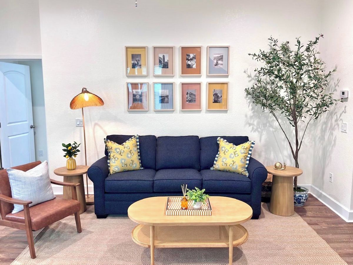 A living room with a sofa, two side tables, a coffee table, and a lamp.