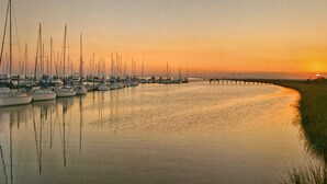 Un port esportiu amb diverses embarcacions amarrades al llarg d'un moll durant el capvespre.