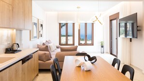 A modern kitchen with a wooden countertop, a dining table, and a sofa. - Villa Santa Irini 3 - With Heated Pool (Agia Eirini)