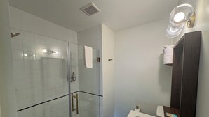 A bathroom with a glass-enclosed shower, a white sink, and a dark wooden vanity. - Non-Smoking King/Queen With Balcony - NKQB (Manitou Springs)