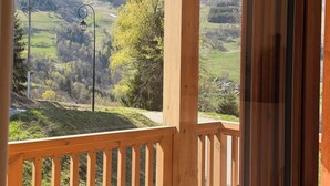 Une terrasse en bois offrant une vue sur un paysage montagneux.