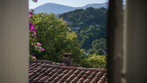 A view from a window overlooking a hillside with houses and trees. - Pied-à-terre de Saint-Paul | Free public parking (Saint-Paul-de-Vence)