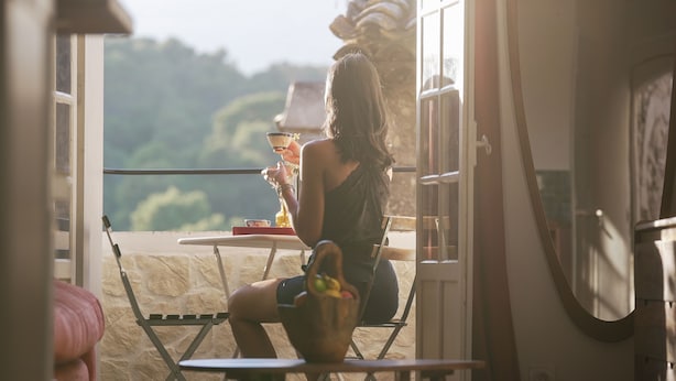 A woman sitting at a table with a view of a mountainous landscape. - Pied-à-terre de Saint-Paul | Free public parking (Saint-Paul-de-Vence)