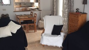 A compact living space with a kitchenette, a dining area, and a seating area with a sofa and armchair. - Beautiful, fully equipped detached villa with a private swimming pool. (Zurgena)
