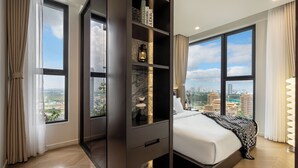 Quarto moderno com uma cama grande, um guarda-roupa embutido e vista para a cidade.