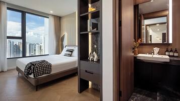A modern hotel room with a large bed, a built-in wardrobe, a vanity with a mirror, and a view of the city skyline.