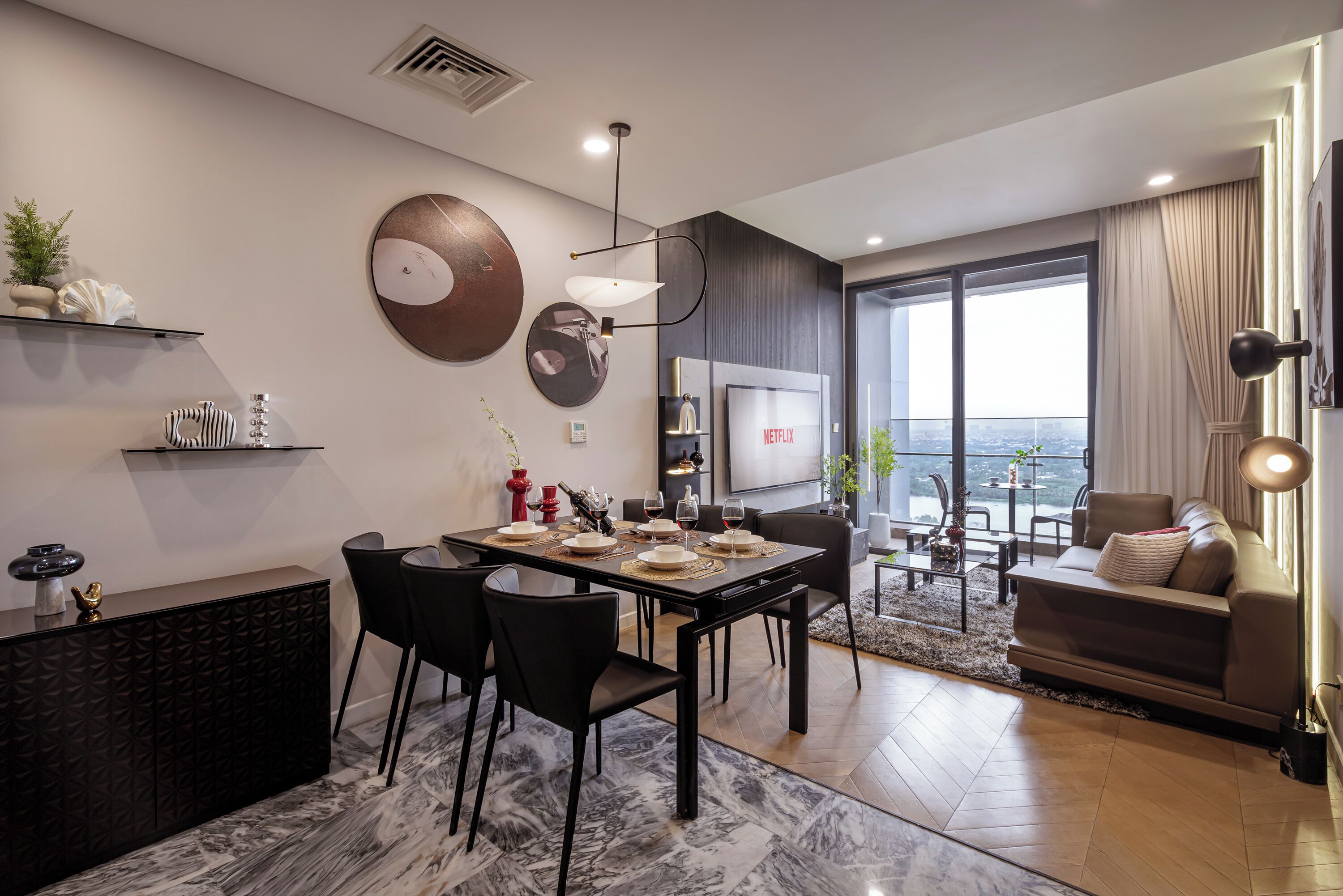 Un salon moderne avec un coin repas, de grandes fenêtres et une vue sur la ville.