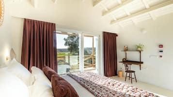 Un dormitorio con cama, escritorio y vistas al exterior.