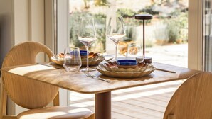 A dining table with chairs, a glass of water, and a wine glass. - Quinta Amala (Grandola)