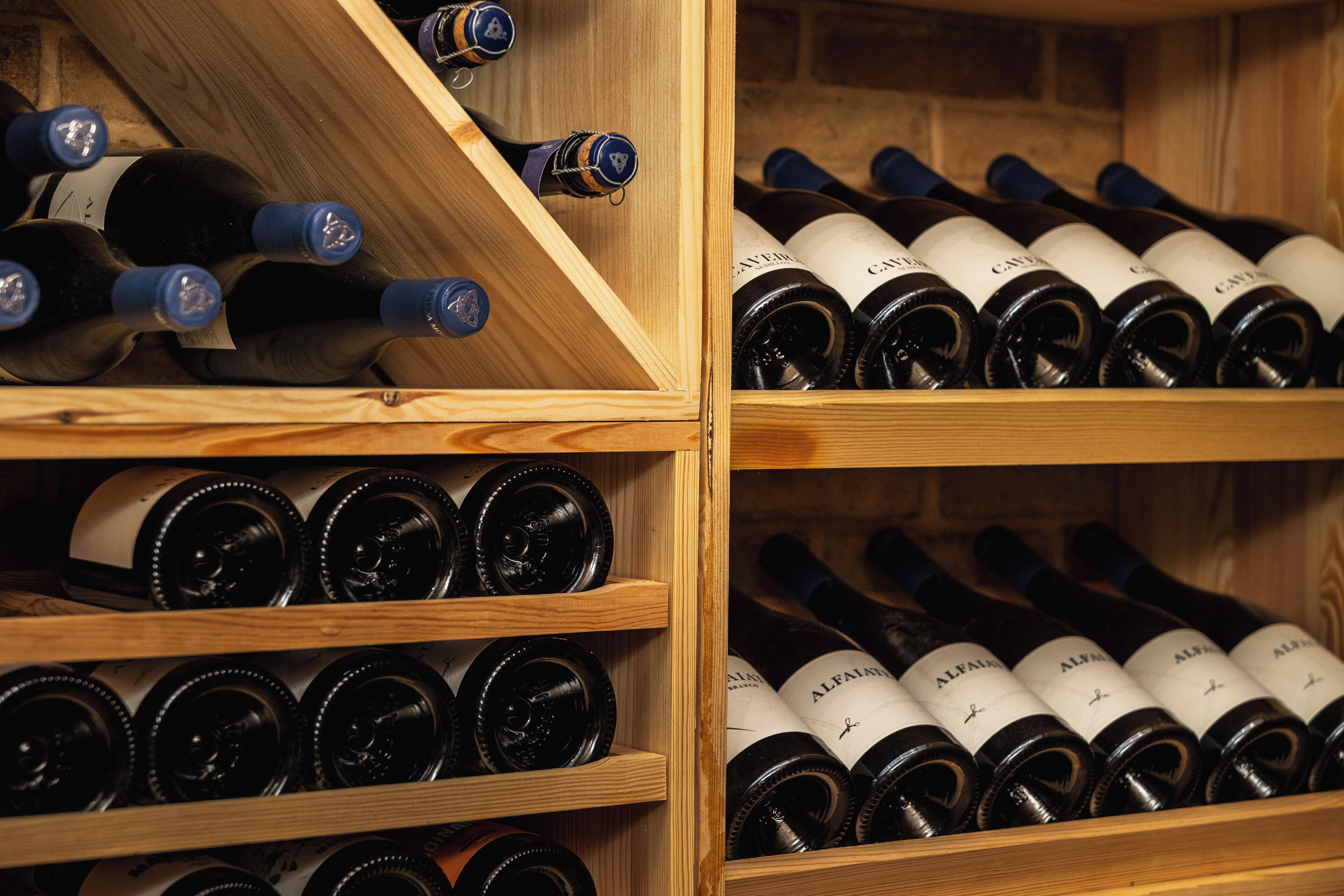 Una botellera de madera con varios estantes que contienen botellas de vino.