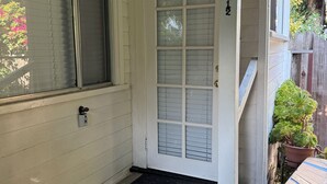 Eine weiße Haustür mit Glasfenster, einem Briefkasten und der Hausnummer 236 an der Wand.