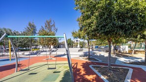 A playground with swings and a red and green play area. - Olga Apt 4- Lovely Studio on Ground Floor (Limassol)