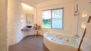 Ein modernes Badezimmer mit einer freistehenden Badewanne, einem großen Fenster mit Blick und einem integrierten Waschtisch.