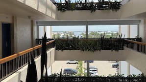 Un atrio de varios niveles con balcones, ventanas amplias y plantas de interior.