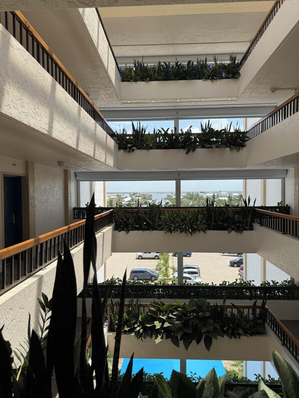 Un atrio de varios niveles con balcones, ventanas amplias y plantas de interior.