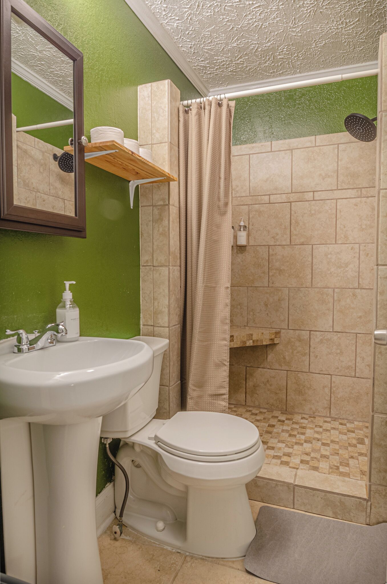 A bathroom with a white sink, toilet, and shower area.
