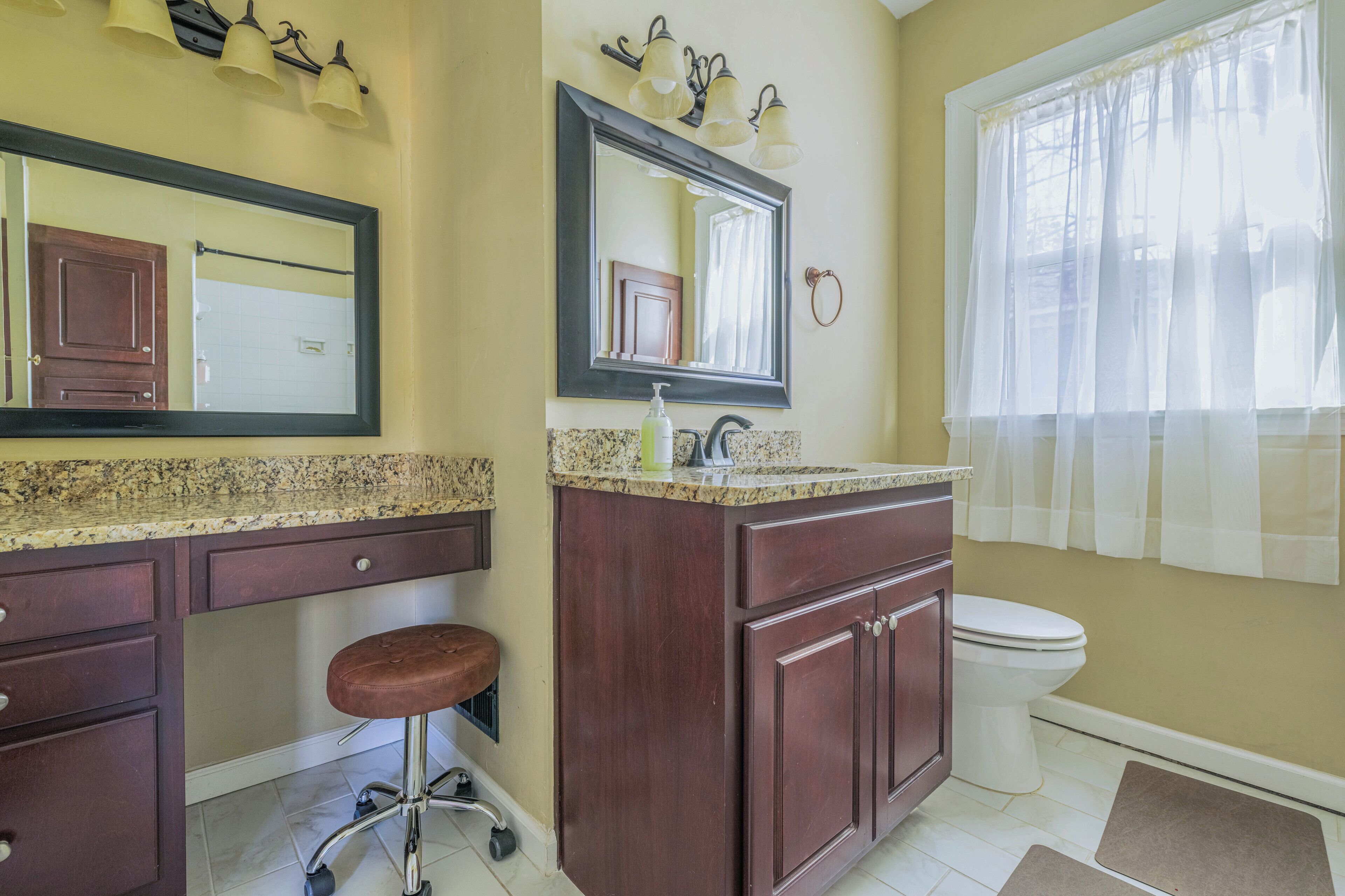 Une salle de bain équipée d’un meuble-lavabo, d’un lavabo, d’un miroir et de toilettes.