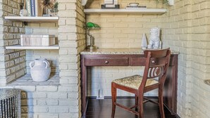 Un bureau en bois, une chaise et des étagères remplies de livres et d’objets décoratifs.