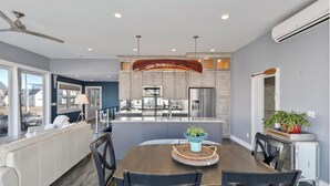 A modern kitchen with grey cabinets, stainless steel appliances, and a central island. - Spacious 6-bedroom house in serene York, Maine, with Central AC (York)
