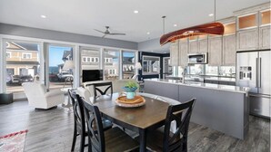 A modern kitchen with a central island, stainless steel appliances, and a view of the outside. - Spacious 6-bedroom house in serene York, Maine, with Central AC (York)