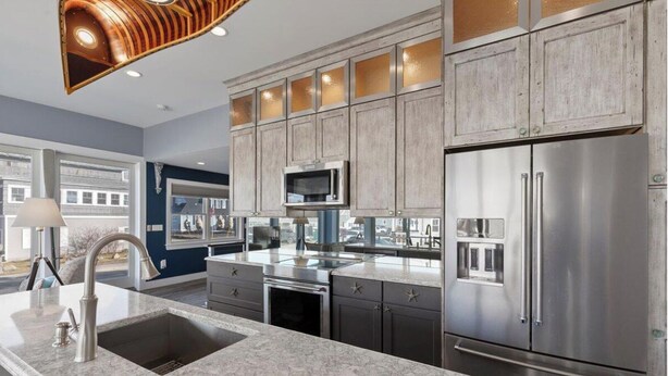 A modern kitchen with stainless steel appliances, a marble countertop, and wooden cabinets. - Spacious 6-bedroom house in serene York, Maine, with Central AC (York)