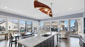 A spacious kitchen with a large island, dark cabinetry, and a unique ceiling light fixture. - Spacious 6-bedroom house in serene York, Maine, with Central AC (York)