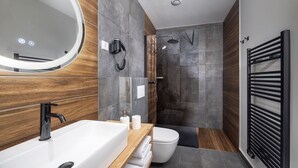 Un bagno moderno con una vasca freestanding, un water e un angolo doccia.