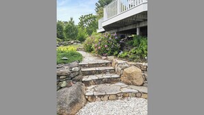A stone pathway leading to a white balcony with a railing.
