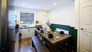 Una cocina moderna con armarios de madera, una mesa de comedor con platos negros y un banco.