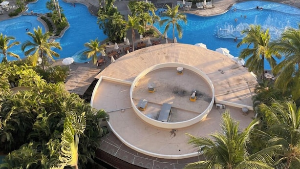 Un resort con varias piscinas rodeadas de palmeras y zonas de descanso.