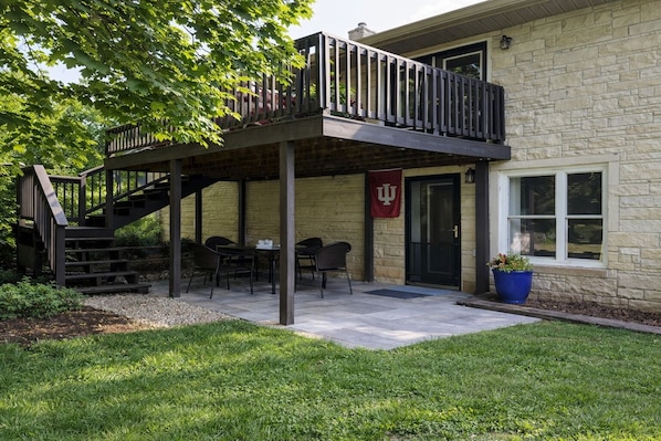 Un patio couvert avec des sièges d’extérieur, un bâtiment en pierre et un drapeau.